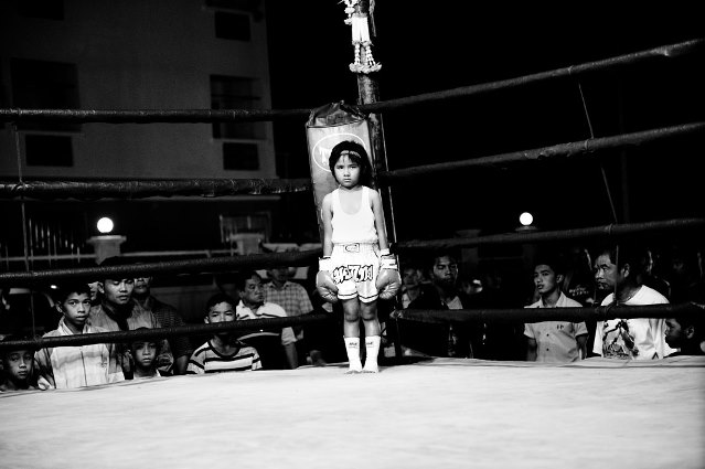 Girl, 6 years, in a boxing ring. Muay Thai (Thai Boxing) is one of the toughest martial arts in the world. A minimum age for the fighters does not exist. For many poor people it secures their livelihood. For a pittance, they reach their mental and physical limits two or three times a month with boxing matches.