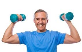 A senior man holding two dumbbells while flexing his muscles.